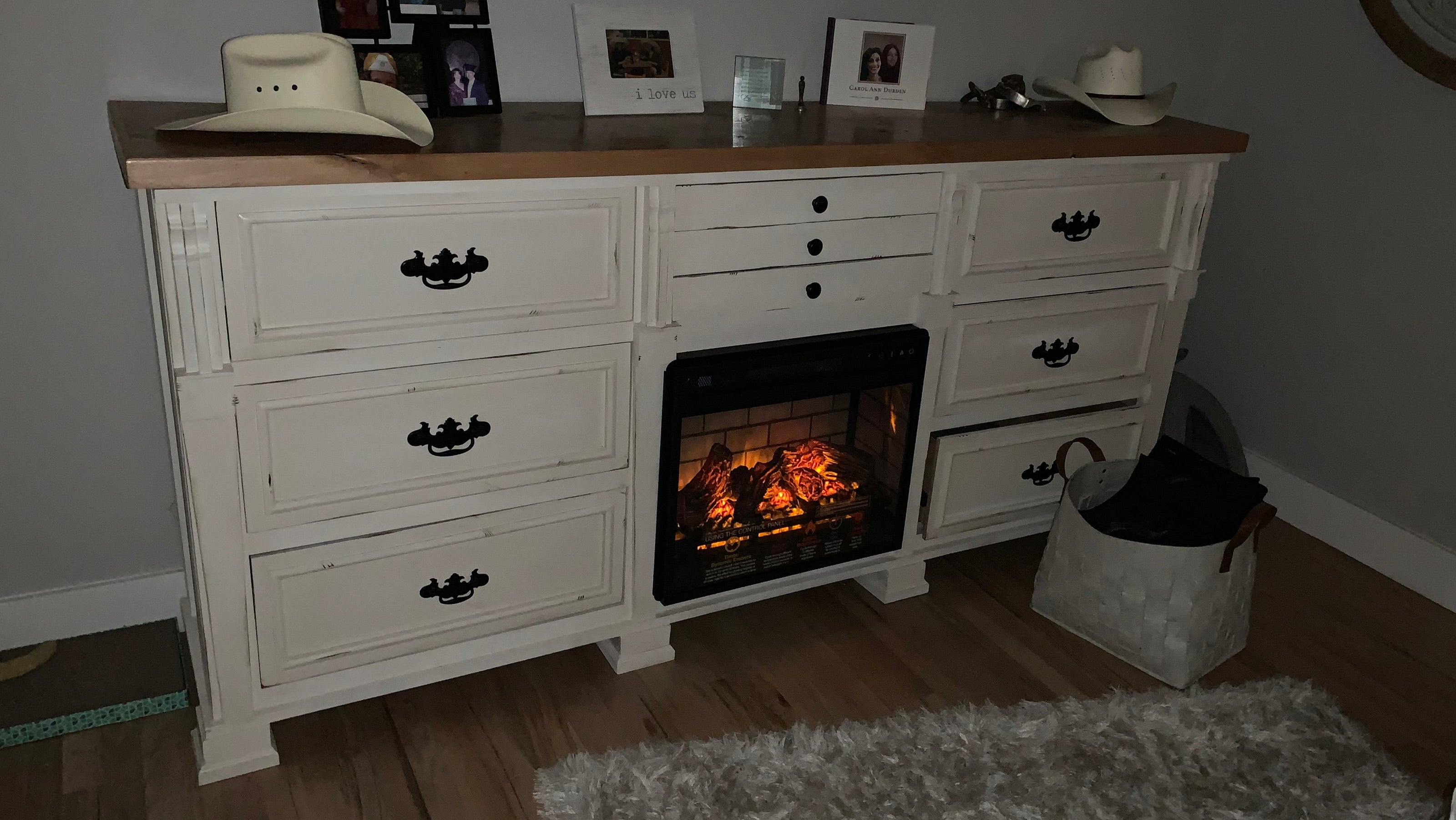 White dresser with built-in fireplace and decorative items in a room. Builtin Jewelry drawer.